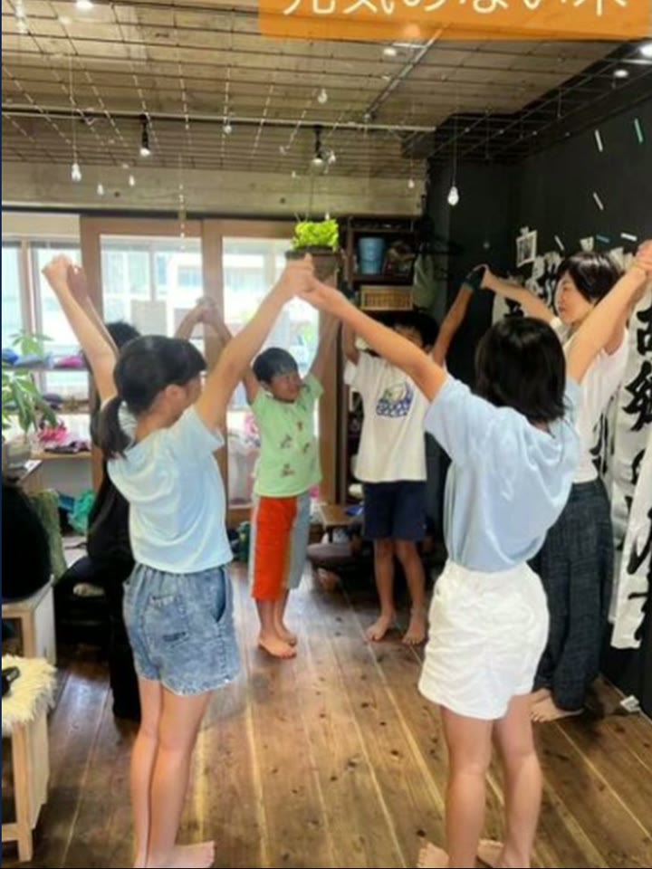 こどもヨーガで両手を上げる子どもたち